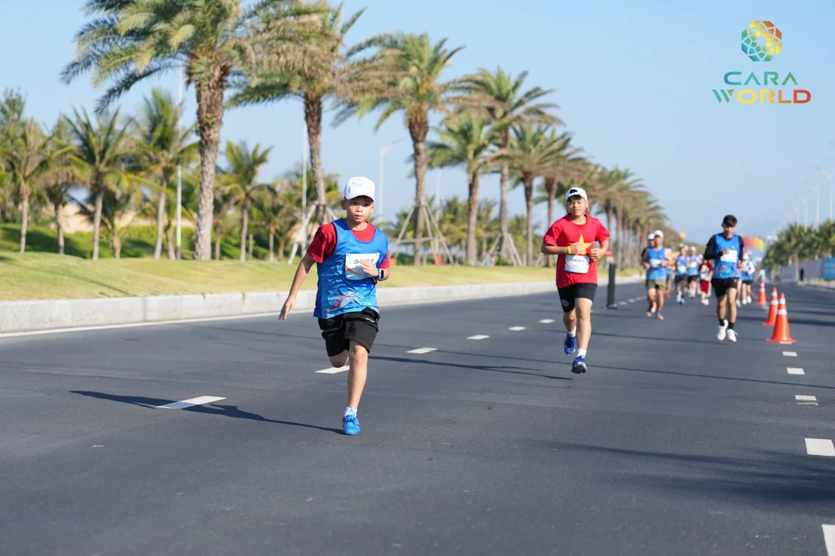 Vận động viên nhí và người lớn chạy trên đại lộ hàng cọ dừa ven biển CaraWorld Cara Run 2026 Vận động viên nhí và người lớn chạy trên đại lộ hàng cọ dừa ven biển CaraWorld Cara Run 2026