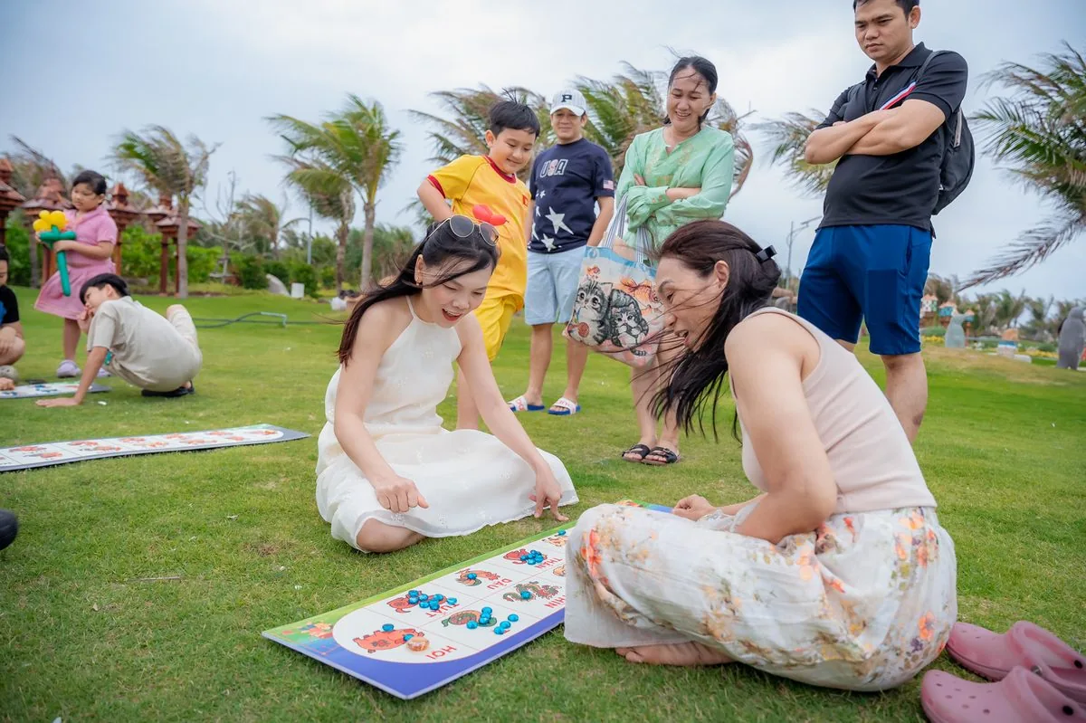 Mẹ và con gái chơi trò chơi board game trên thảm cỏ xanh công viên CaraWorld Cam Ranh